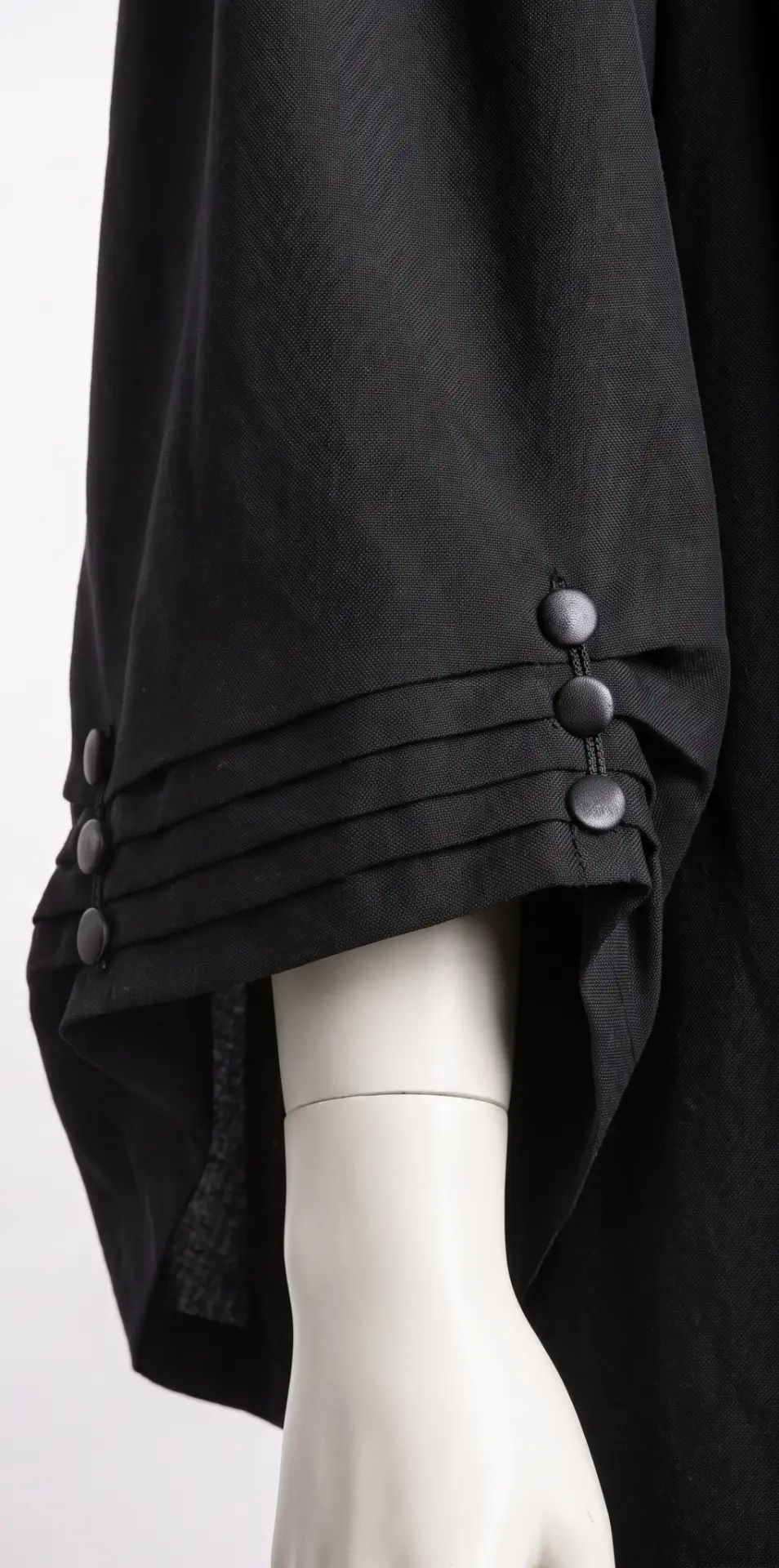 Covered buttons and pleats on the cuff of the barrister gown